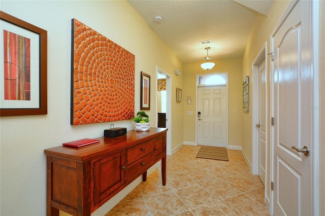 tiled entrance foyer featuring a textured ceiling