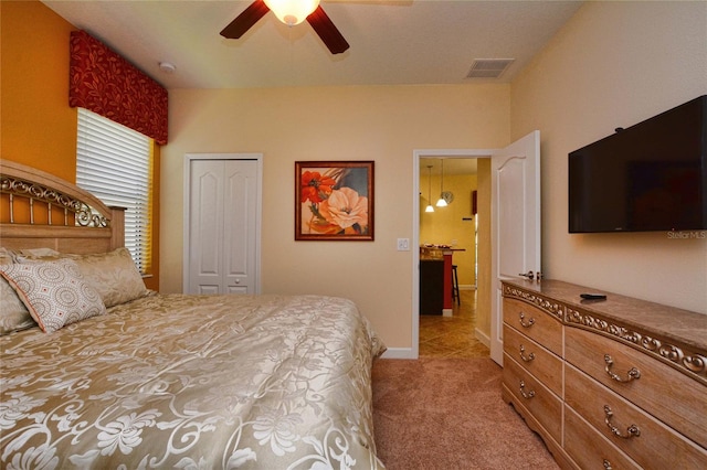 bedroom with light colored carpet, a closet, and ceiling fan