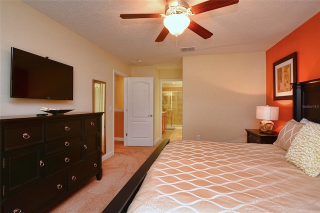 carpeted bedroom featuring ensuite bathroom, ceiling fan, and a textured ceiling