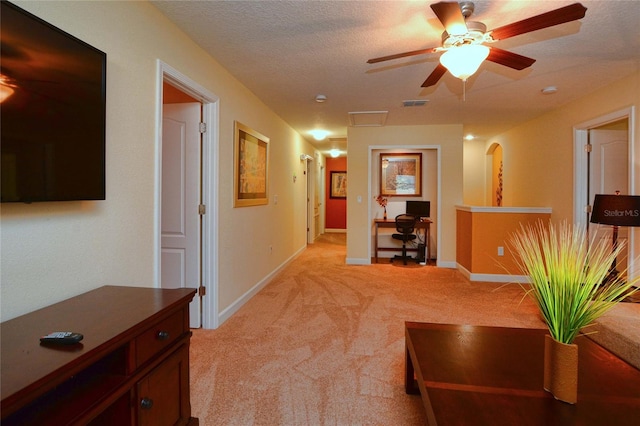 interior space with light colored carpet, ceiling fan, and a textured ceiling