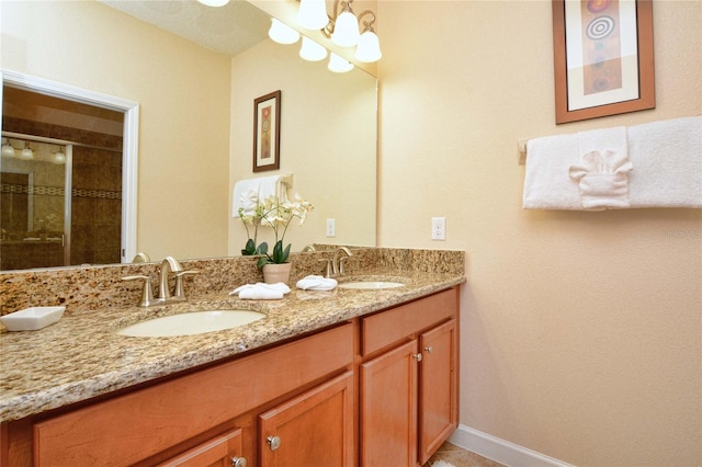 bathroom with dual bowl vanity and an inviting chandelier