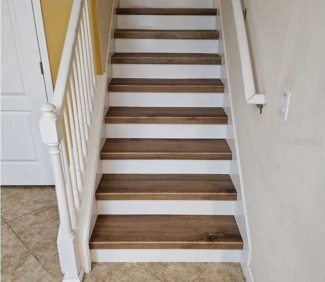 staircase featuring light tile flooring