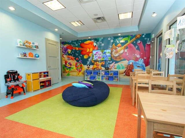 game room with a raised ceiling and a paneled ceiling