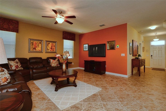 tiled living room with a textured ceiling and ceiling fan