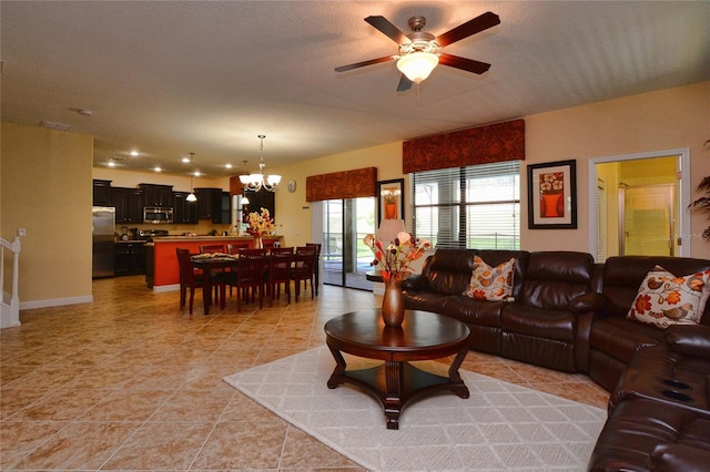 living room with ceiling fan with notable chandelier and light tile flooring