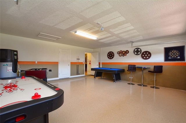 game room featuring water heater, a textured ceiling, and billiards