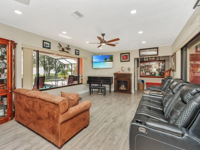 living room with ceiling fan and light hardwood / wood-style flooring