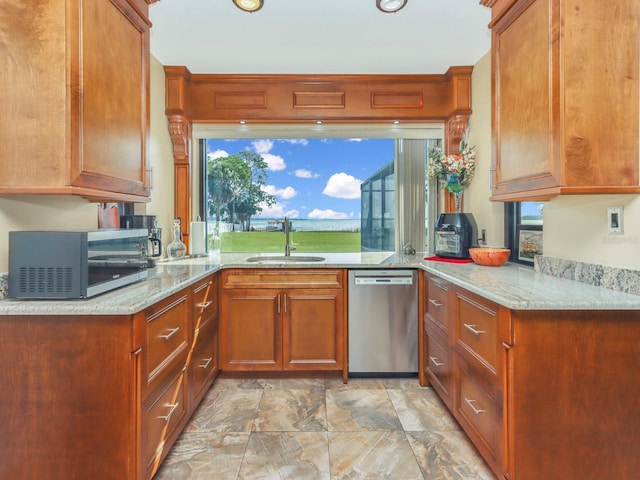 kitchen featuring plenty of natural light, stainless steel appliances, sink, and light stone countertops