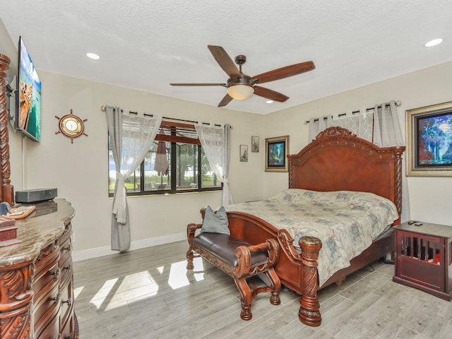 bedroom featuring ceiling fan, light hardwood / wood-style flooring, and a textured ceiling