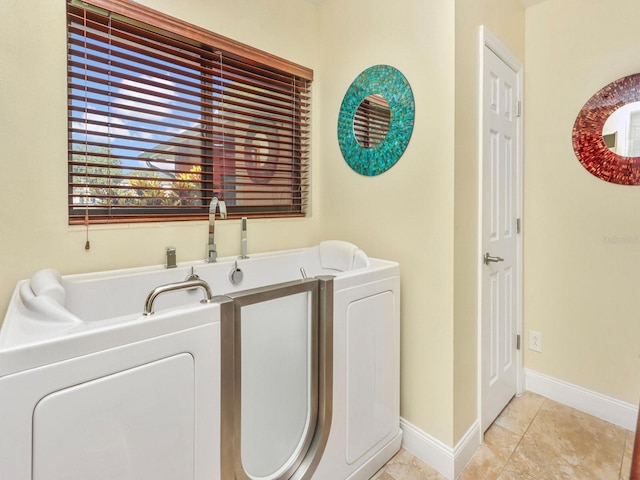 washroom featuring light tile flooring and washer and dryer