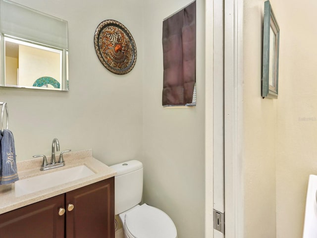 bathroom featuring vanity with extensive cabinet space and toilet