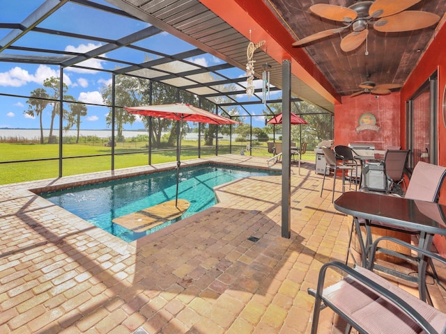 view of swimming pool with a lanai, a patio area, ceiling fan, and a lawn