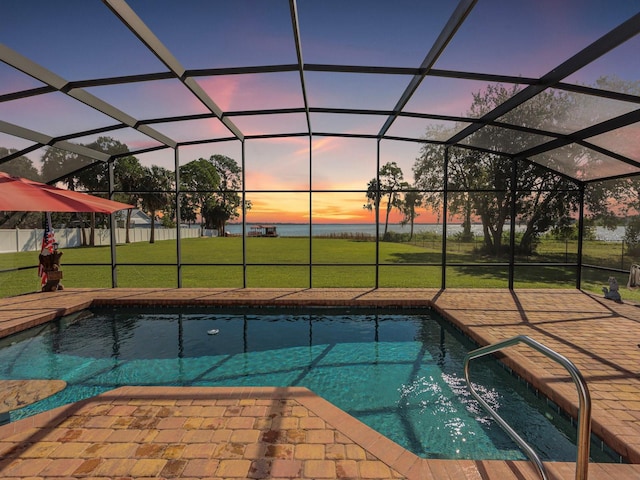 pool at dusk featuring a patio area, a lawn, and a lanai