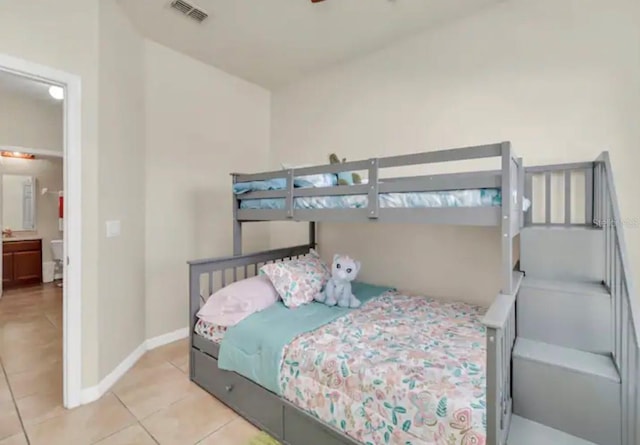 bedroom with light tile floors and ensuite bath