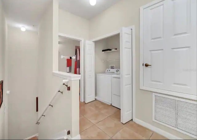 corridor featuring light tile flooring and washer and clothes dryer