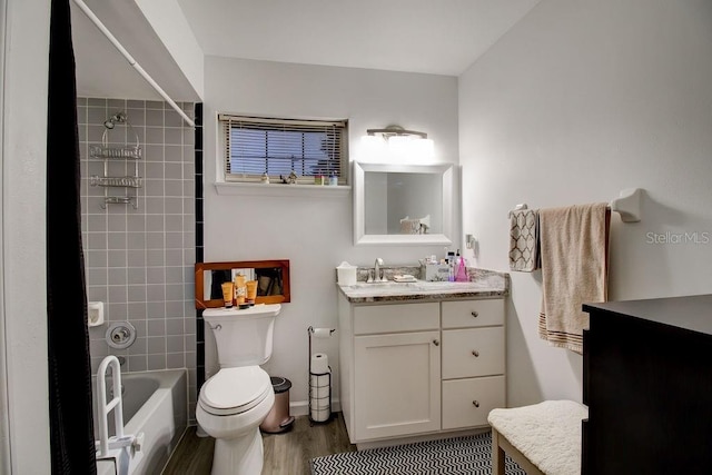 full bathroom featuring tiled shower / bath, vanity, wood-type flooring, and toilet