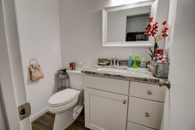 bathroom with hardwood / wood-style flooring, vanity, and toilet