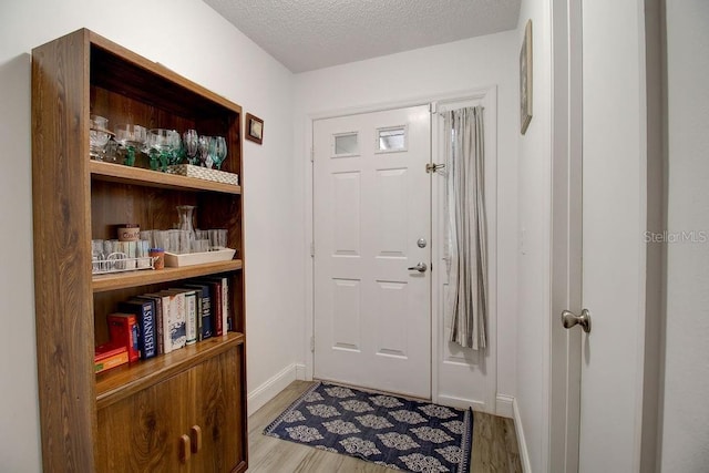 entrance foyer with light hardwood / wood-style flooring and a textured ceiling