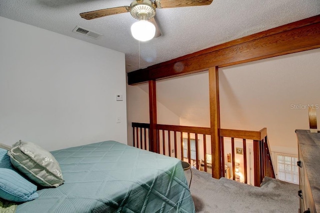 bedroom with carpet flooring, ceiling fan, and a textured ceiling