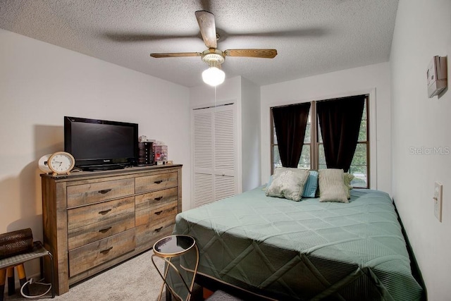 carpeted bedroom with a textured ceiling, a closet, and ceiling fan