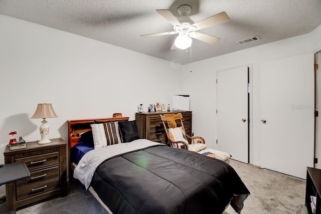 carpeted bedroom featuring a textured ceiling and ceiling fan