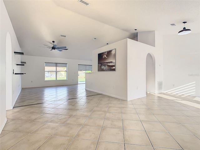 empty room with lofted ceiling, light tile patterned flooring, and ceiling fan