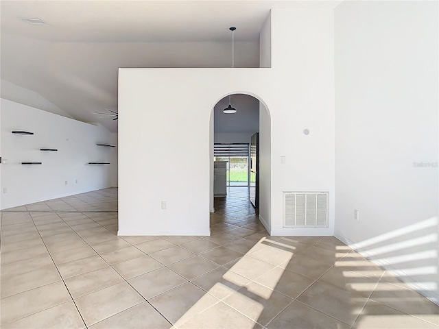 unfurnished room featuring vaulted ceiling, light tile patterned flooring, and ceiling fan