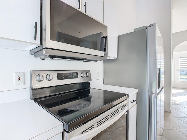 kitchen featuring appliances with stainless steel finishes, white cabinets, and light tile patterned floors