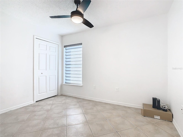 unfurnished bedroom featuring a closet, ceiling fan, and light tile patterned floors