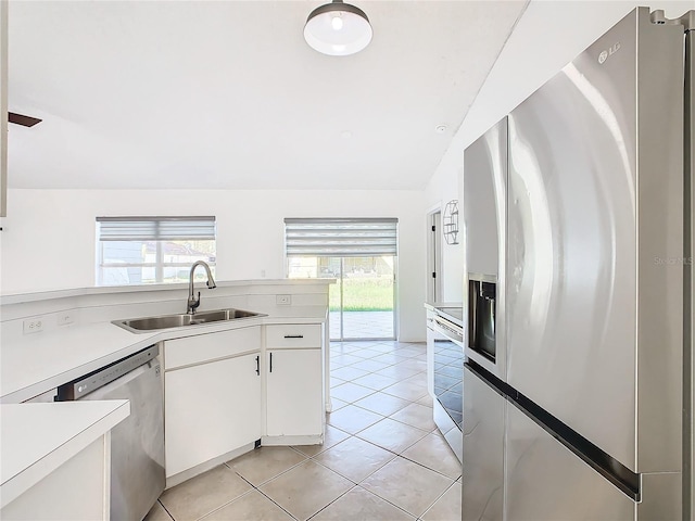 kitchen with a wealth of natural light, sink, white cabinetry, and stainless steel appliances