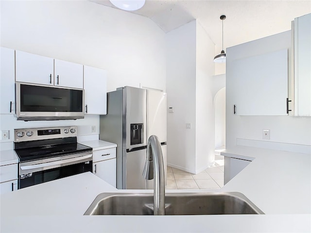 kitchen featuring hanging light fixtures, sink, white cabinetry, light tile patterned floors, and appliances with stainless steel finishes