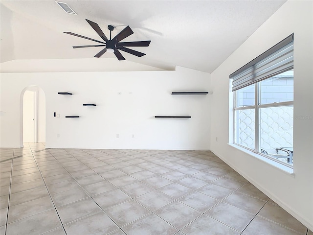 tiled empty room featuring ceiling fan and vaulted ceiling