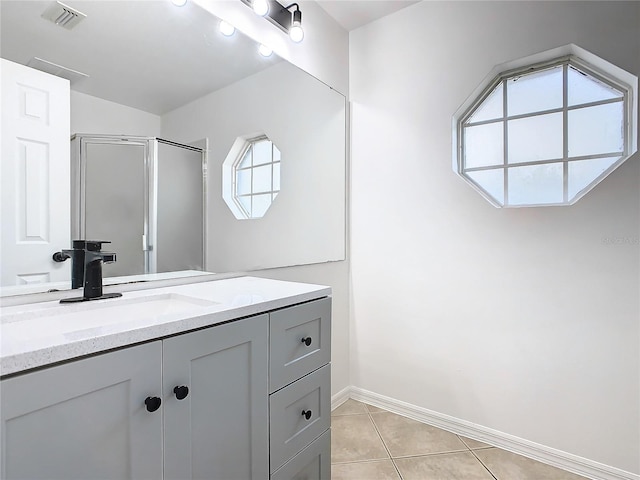 bathroom with vanity, tile patterned flooring, a shower with shower door, and a wealth of natural light