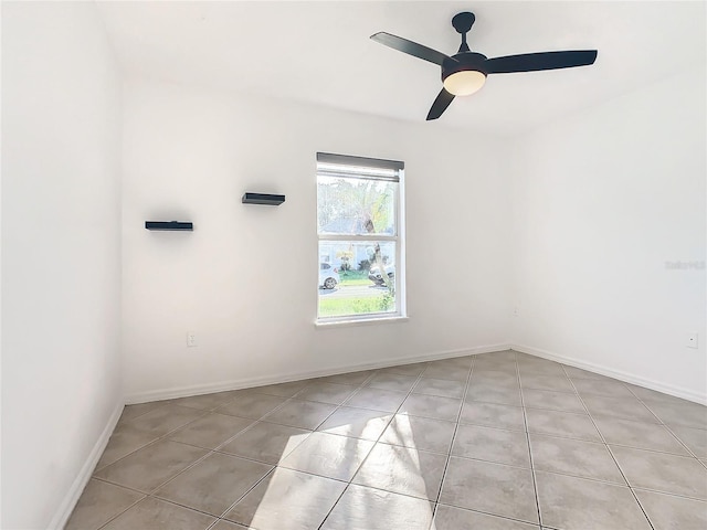 tiled spare room with ceiling fan