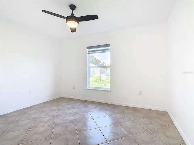 tiled empty room featuring ceiling fan