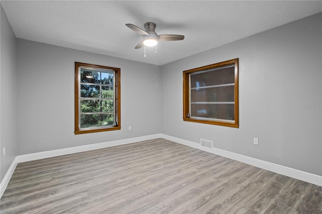 spare room with ceiling fan and light wood-type flooring