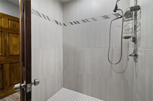 bathroom featuring hardwood / wood-style flooring and tiled shower