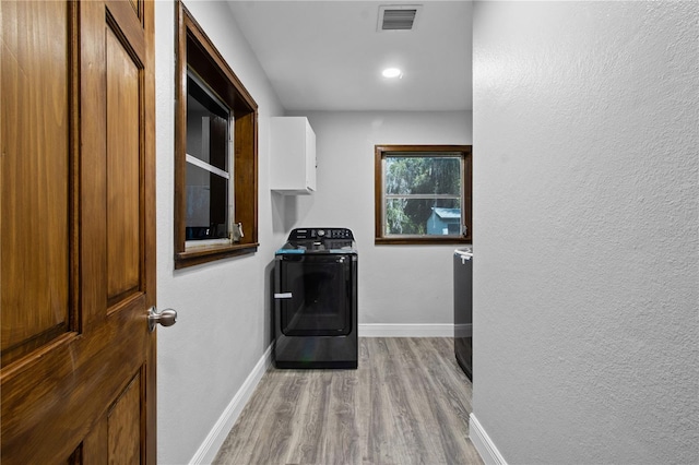 washroom with washing machine and dryer and light wood-type flooring