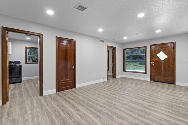 entryway with light hardwood / wood-style floors and a textured ceiling