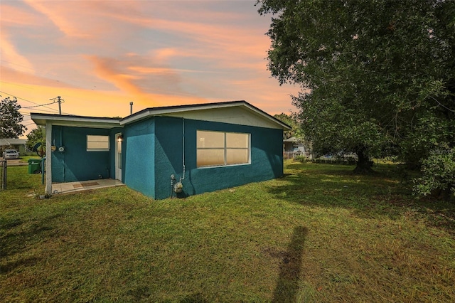 property exterior at dusk with a yard