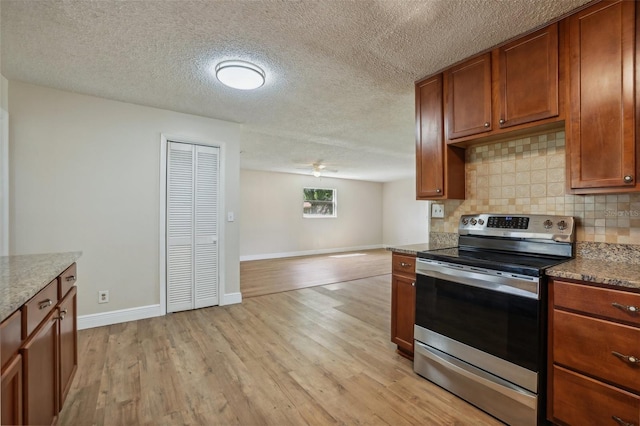 kitchen featuring stainless steel range with electric cooktop, light wood-type flooring, backsplash, and a textured ceiling