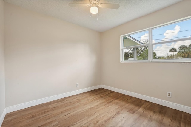 empty room with ceiling fan, a textured ceiling, and light hardwood / wood-style floors