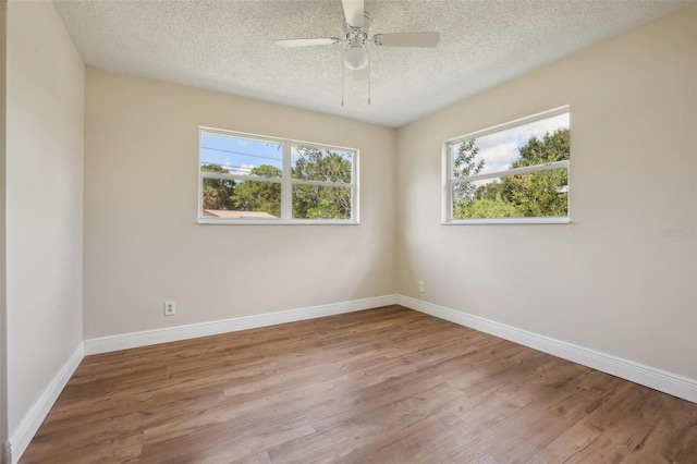 spare room with light hardwood / wood-style floors, ceiling fan, and a textured ceiling