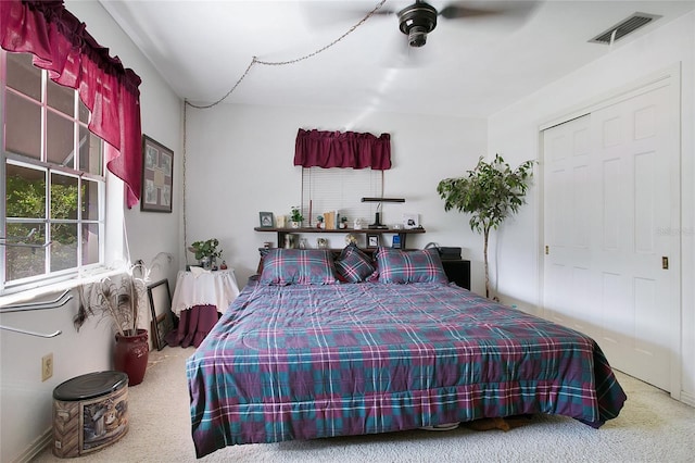 carpeted bedroom featuring a closet and ceiling fan