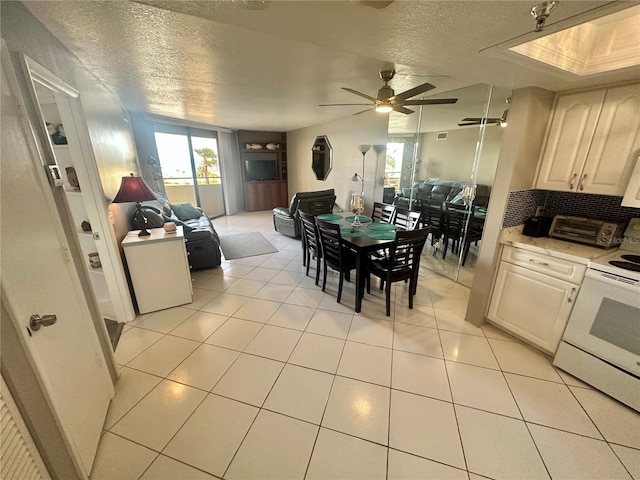 tiled dining room featuring ceiling fan and a textured ceiling