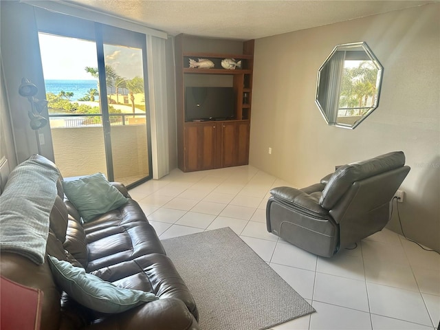 living room with light tile floors, a textured ceiling, and a water view