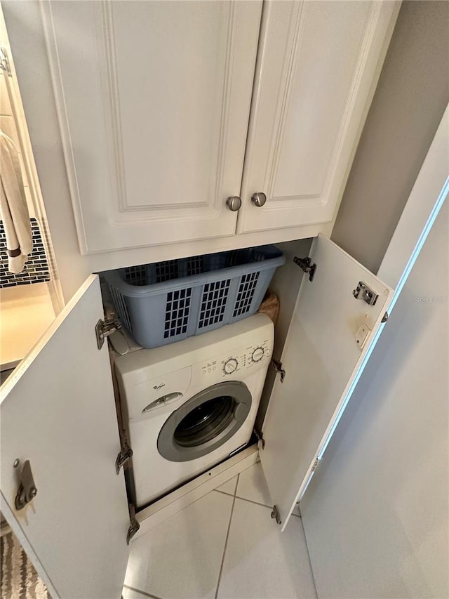 laundry area with cabinets, tile floors, and washer / clothes dryer