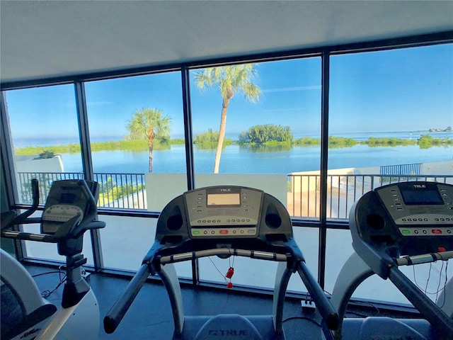 exercise room with a water view