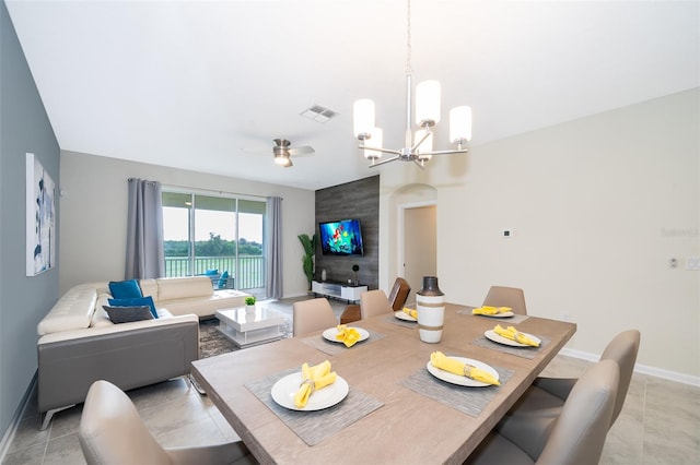 tiled dining space featuring ceiling fan with notable chandelier