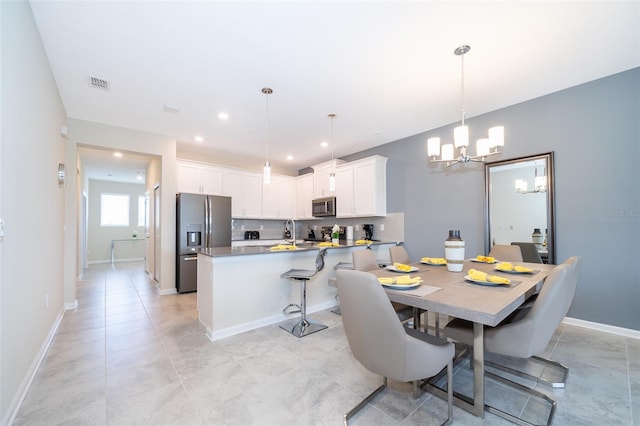 tiled dining room featuring an inviting chandelier